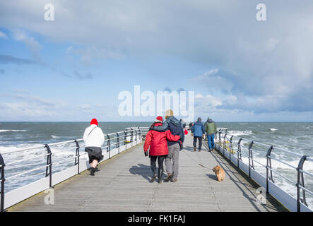 Saltburn by the sea, North Yorkshire, England, UK, 5th March 2016. Weather: well wrapped up for a Saturday stroll on Saltburn`s Victorian pier as an icy wind blows in off the cold North sea. Credit:  Alan Dawson News/Alamy Live News Stock Photo