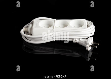 White plastic electrical outlet extension isolated on black reflecting background Stock Photo