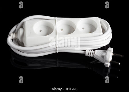 White plastic electrical outlet extension isolated on black reflecting background Stock Photo