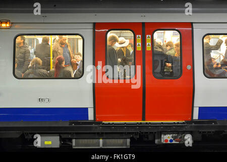 London Underground crowded train carriage of standing Circle Line tube passengers commuting in the rush hour