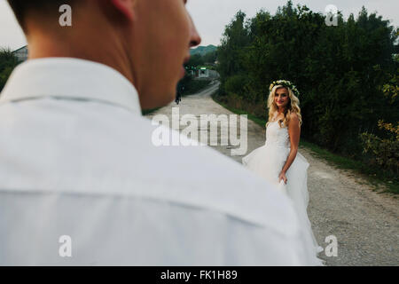 bride leads groom on the road Stock Photo