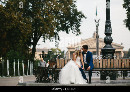 Wedding couple relaxing on a bench Stock Photo