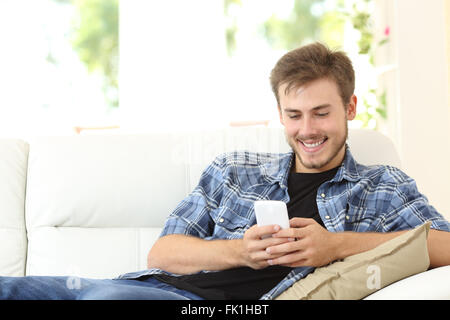 Man using a smart phone at home sitting on a couch at home Stock Photo