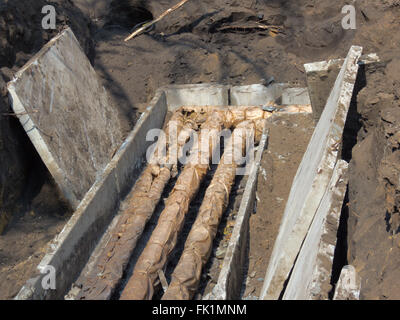 Insulated pipes of heating network, in an opened littered concrete tray Stock Photo