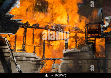 A house is consumed by flames in a blazing fire. Stock Photo