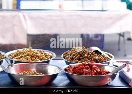Sun dried tomatoes and olives on a market stall Stock Photo