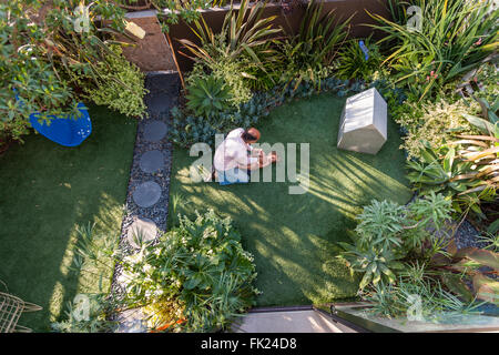 VENICE, CA – AUGUST 19: Glen Irani and son Marlo Irani relax on their artificial grass in Venice, California on August 19, 2005. Stock Photo