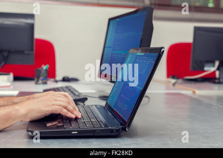 Developer working on source codes on laptop at office. Stock Photo