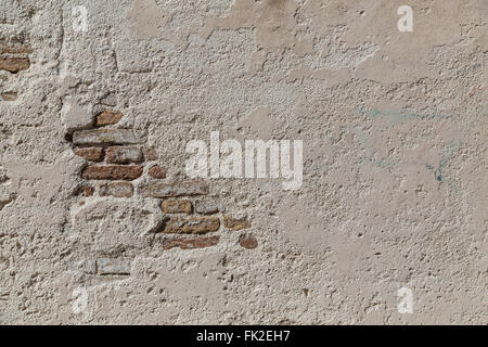Grey Stone Wall Background with space for text. Bricks can be seen behind a cement layer. Stock Photo