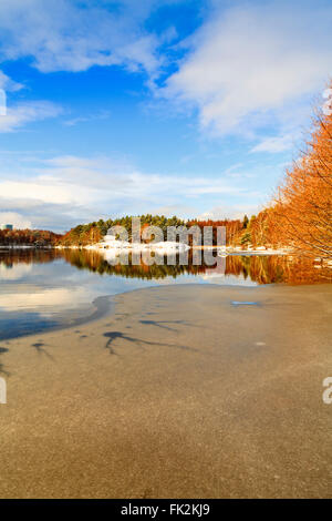 Lake Sisjon (Sisjön) partially covered in ice in the winter, Mölndal or Gothenburg (half of the lake belongs to each town), Sweden.  Model Release: No.  Property Release: No. Stock Photo