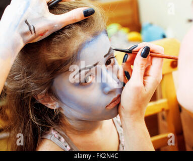 little cute child making facepaint on birthday party, zombie Apocalypse facepainting, halloween preparing concept Stock Photo