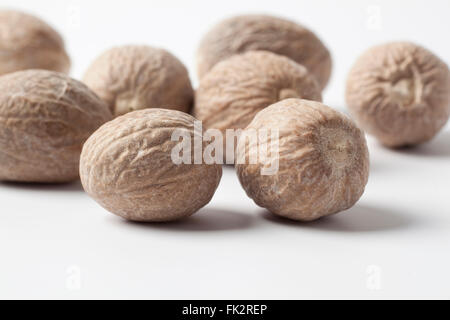 Several whole Nutmeg on a white background Stock Photo