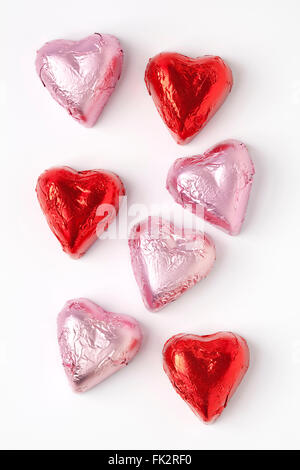 Chocolate hearts in pink and red tinfoil on white background Stock Photo