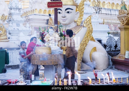 Buddhists lighting incense at the Buddhist Schwedagon pagoda, Yangon, Myanmar Stock Photo