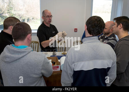 Adult men being taught engineering and pneumatics by qualified engineer instructor. Stock Photo