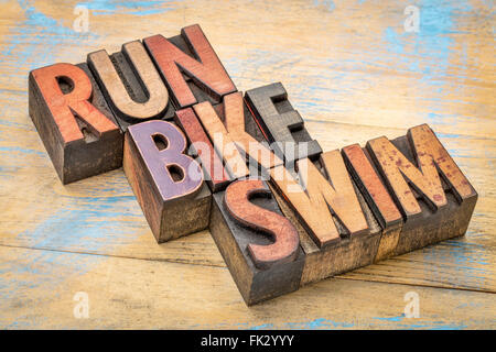 triathlon concept - run, bike and swim word abstract in vintage letterpress wood type printing blocks Stock Photo