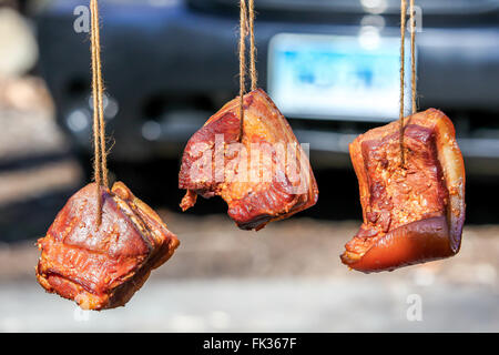 Three bacon hanging outside Stock Photo