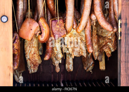 Sausages and bacon inside wooden smokers Stock Photo
