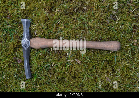 Hand made blacksmith hammer lying on the grass Stock Photo