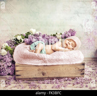 Sleeping toddler lying on purple flowers and blanket Stock Photo