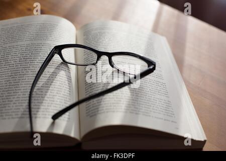 A pair of glasses on top of a book. Stock Photo