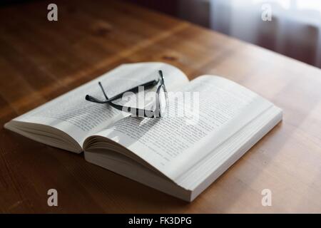A pair of glasses on top of a book. Stock Photo