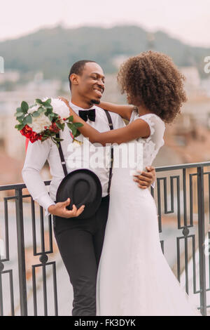 Happy african bride and groom softly hugging Stock Photo
