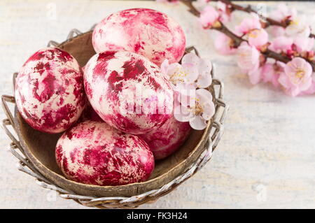 Decorated Easter eggs and fresh cherry blossom tree Stock Photo