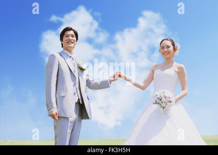 Japanese bride and groom in a city park Stock Photo