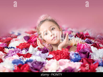 Cute little girl with a bunch of colorful flowers Stock Photo