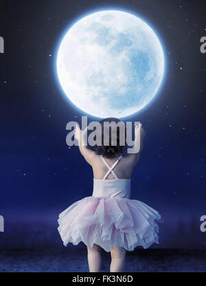 Cute baby girl reaching to the moon Stock Photo