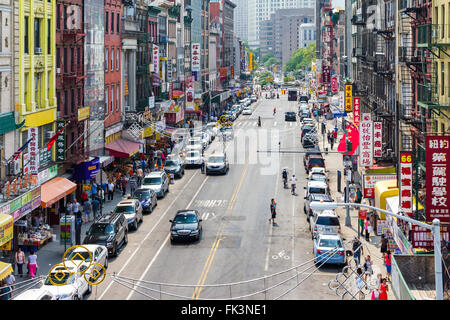 NEW YORK CITY - JULY 2015: Tourists shop at businesses along a busy street in historic Chinatown during 4th of July festivities Stock Photo