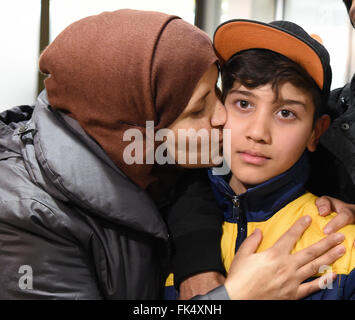 Hanover, Germany. 07th Mar, 2016. Afghan refugee boy Mahdi Rabani gets a kiss his mother Shockria in the arrivals hall of the Hanover-Langenhagen Airport with a bouquet of flowers in Hanover, Germany, 07 March 2016. Mahdi went missing at the start of 2015 during passage to Greece. An aid-worker with the German Red Cross did not give up and eventually tracked down the 10-year-old boy in Switzerland, where he had landed with another Afghan family. Photo: HOLGER HOLLEMANN/dpa/Alamy Live News Stock Photo