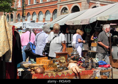 Shoppers look at vintage and second hand items for sale at the Thursday flea market in Market Place,Chesterfield, Derbyshire UK Stock Photo