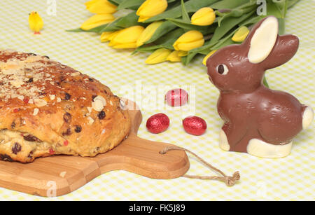 Traditional whole dutch easter bread and chocolate easter eggs, yellow, tulips and a chocolate bunny Stock Photo