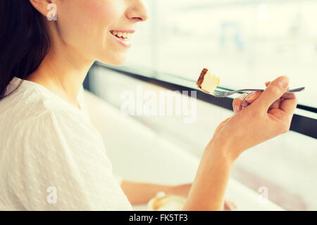 close up of woman eating cake at cafe or home Stock Photo