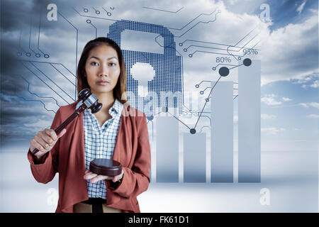 Composite image of businesswoman banging a law hammer on the gavel Stock Photo