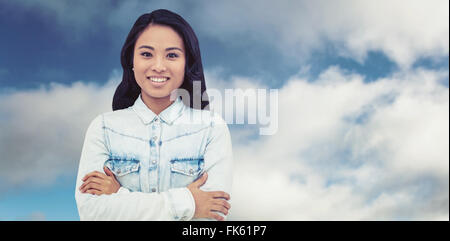 Composite image of asian woman with arms crossed smiling Stock Photo