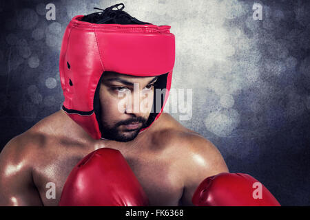 Composite image of muscular man boxing in gloves Stock Photo