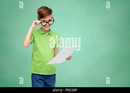 happy boy in eyeglasses holding school test result Stock Photo