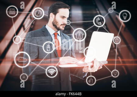 Composite image of focused businessman using his laptop Stock Photo