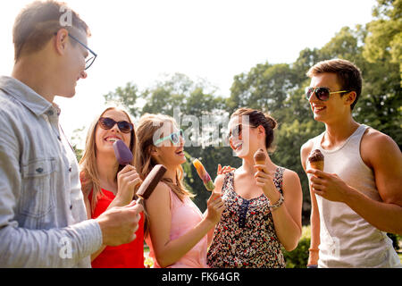 group of smiling friends with ice cream outdoors Stock Photo