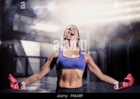 Composite image of winning fighter with arms outstretched Stock Photo
