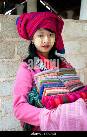 Young girl with thanaka paste on her face, selling scarves and sarongs at Nyaung Oak Monastery, Indein, Inle Lake, Shan state Stock Photo