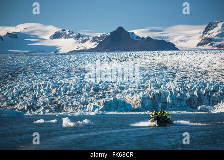 Zodiac boat tour on Jokulsarlon Glacier Lagoon, with Breidamerkurjokull Glacier and Vatnajokull Ice Cap behind, Iceland Stock Photo