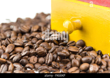 coffe beans in front of a coffe grinder with white background