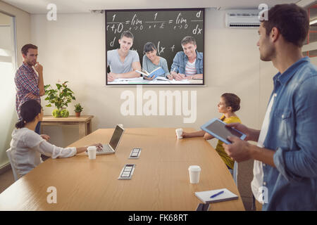 Composite image of students doing work together as they all look into the camera Stock Photo