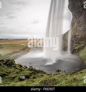 Behind Seljalandsfoss, a famous waterfall just off route 1 in South Iceland (Sudurland), Iceland, Polar Regions Stock Photo