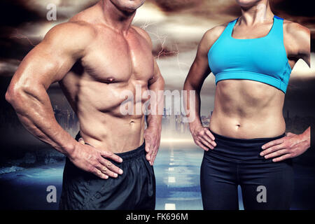 Composite image of midsection of muscular man and woman with hands on hip Stock Photo