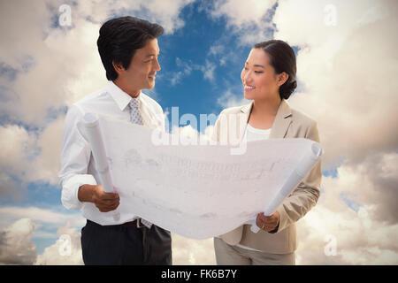 Composite image of estate agent looking at blueprint with potential buyer Stock Photo